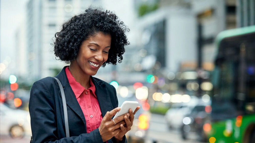 Image of woman smiling while looking at her cell phone